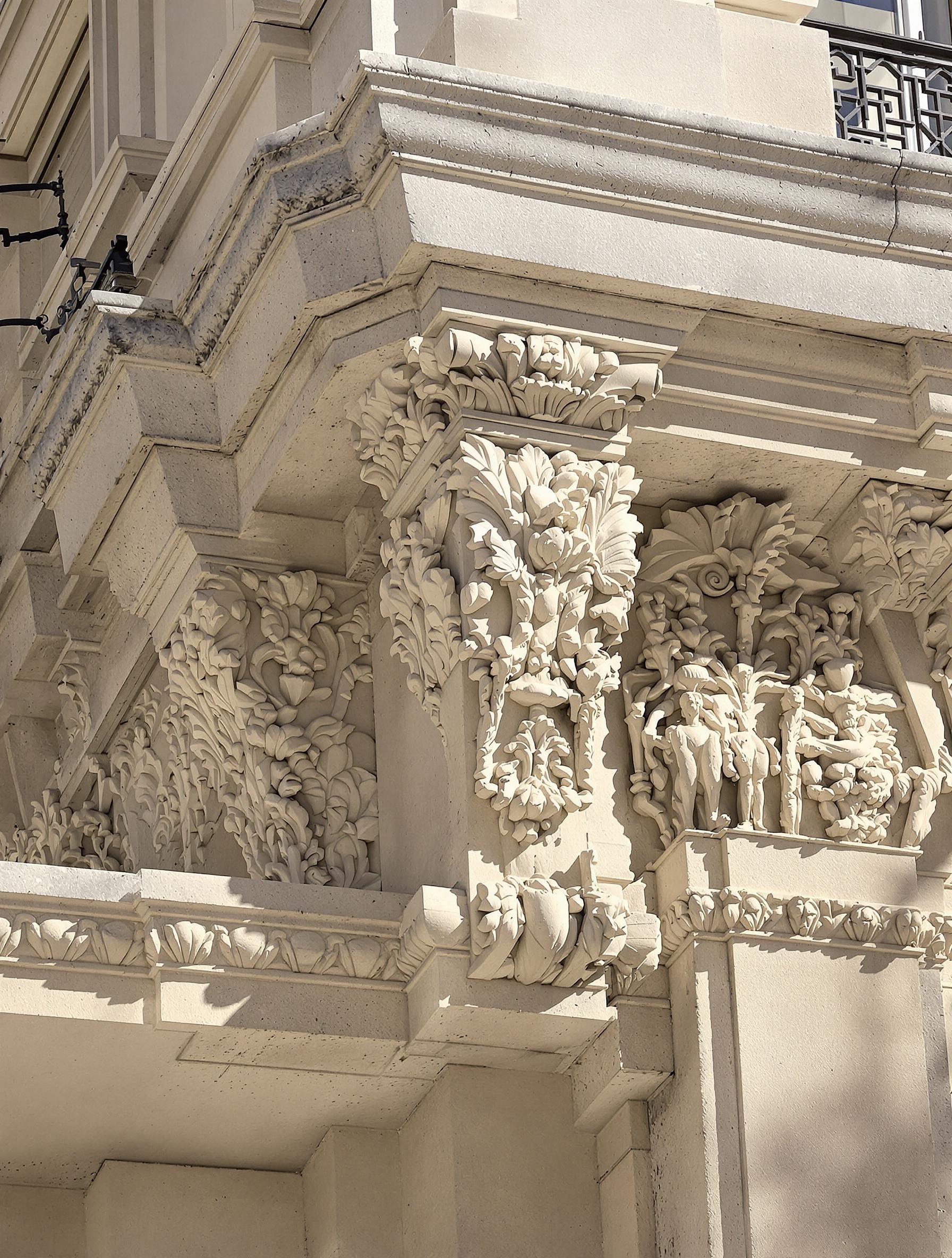 Corniche haussmannienne sculptée en pierre de taille ornée de denticules avec des ombres marquées.