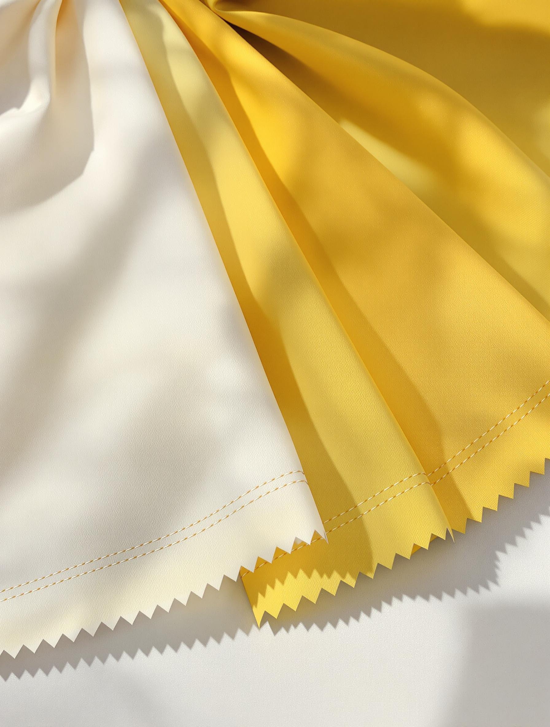 Échantillons de tissus jaunes Oeko Tex posés en éventail sur une table d'atelier, différentes textures visibles.