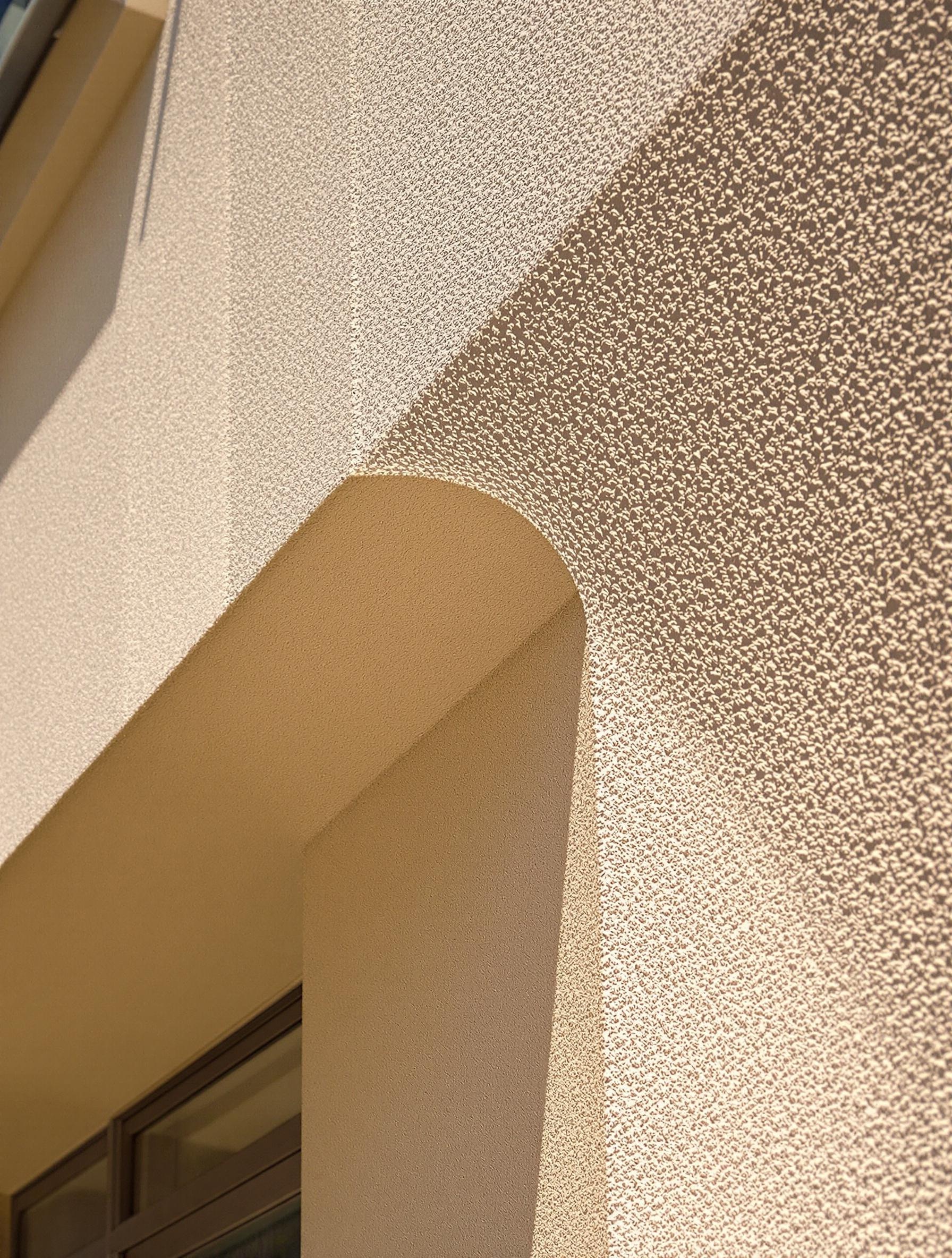 Façade avec enduit gratté jouant avec la lumière et les ombres