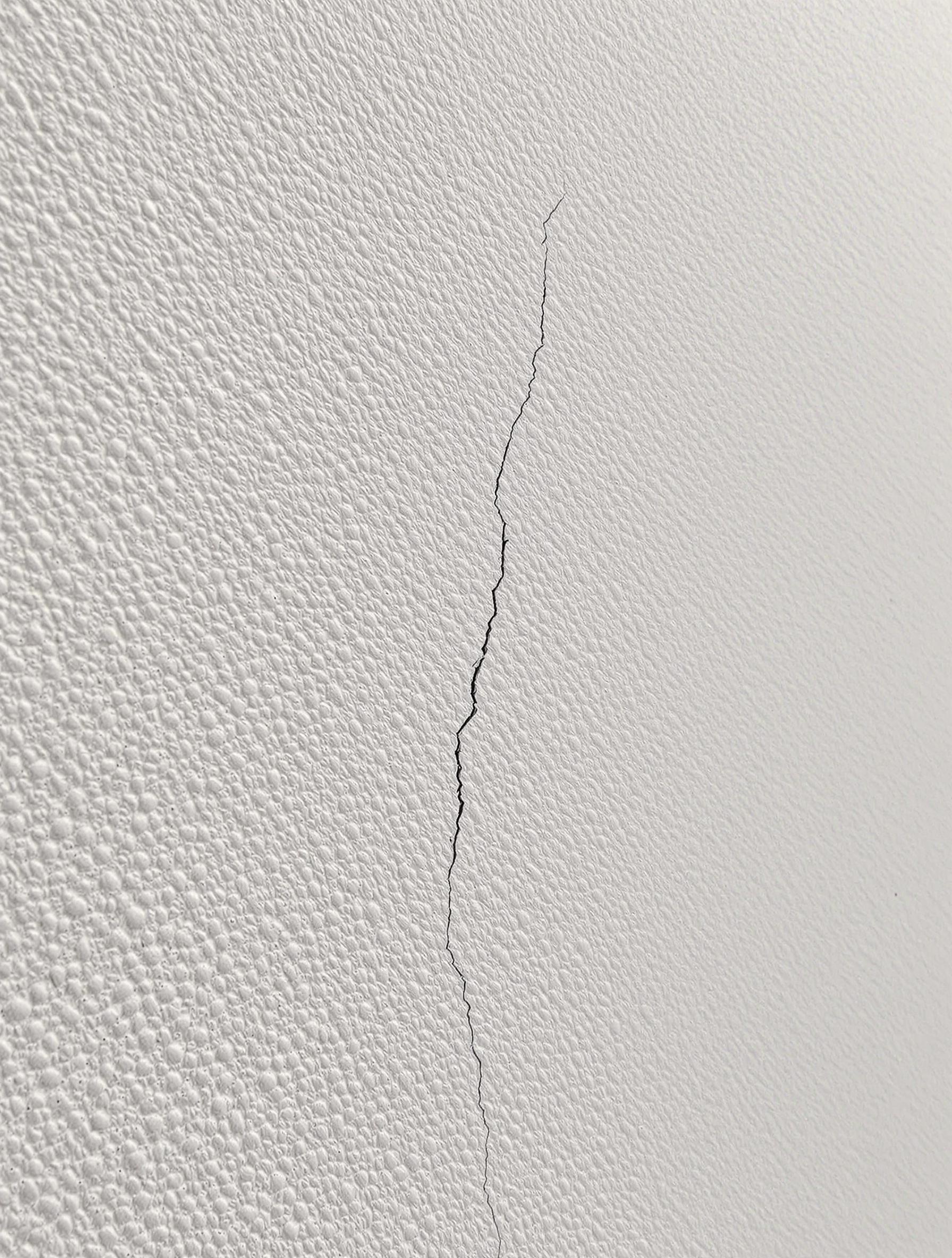 Gros plan sur une microfissure de façade de moins de 0,2 mm