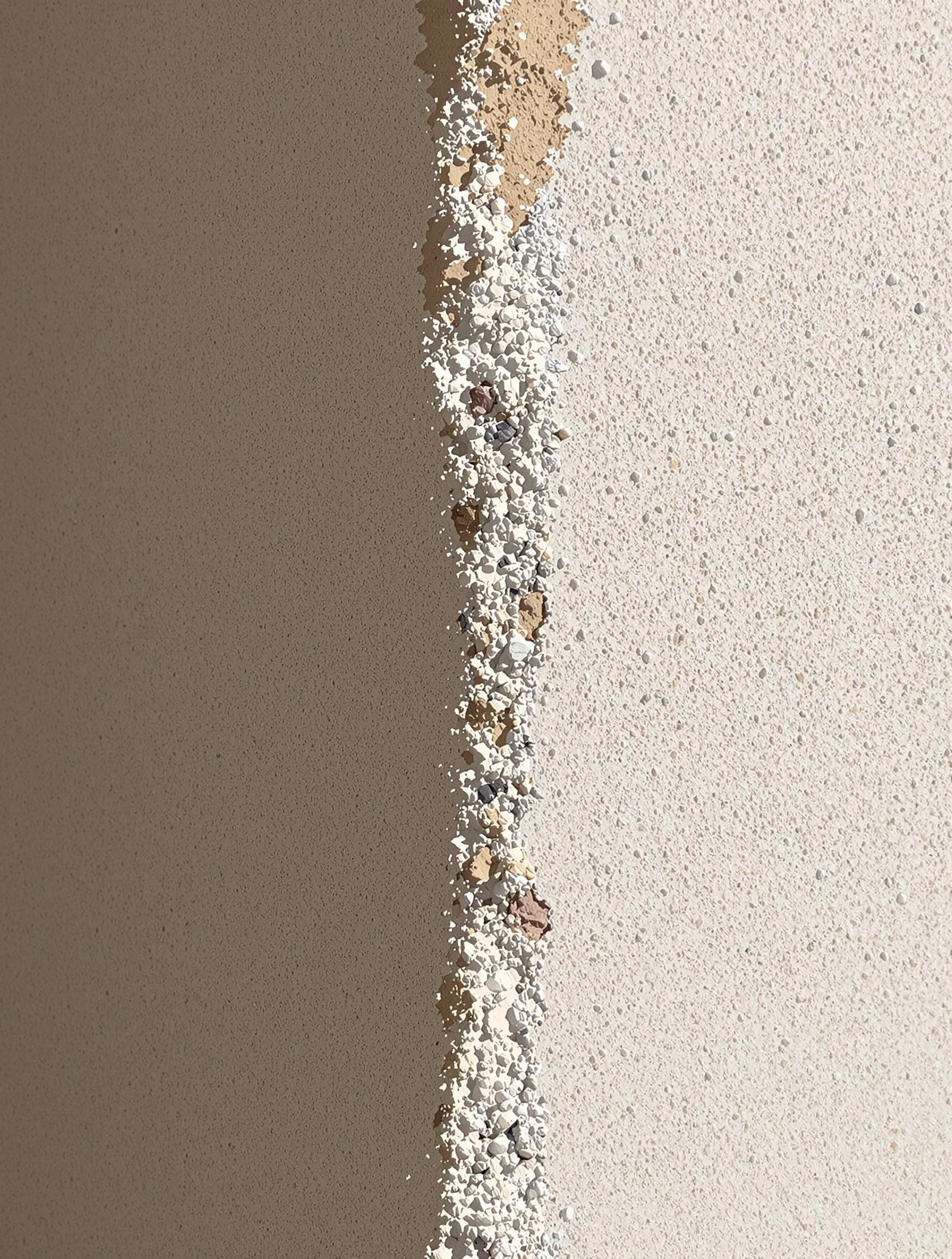 Gros plan d’un mur en enduit RME granuleux avec texture grattée