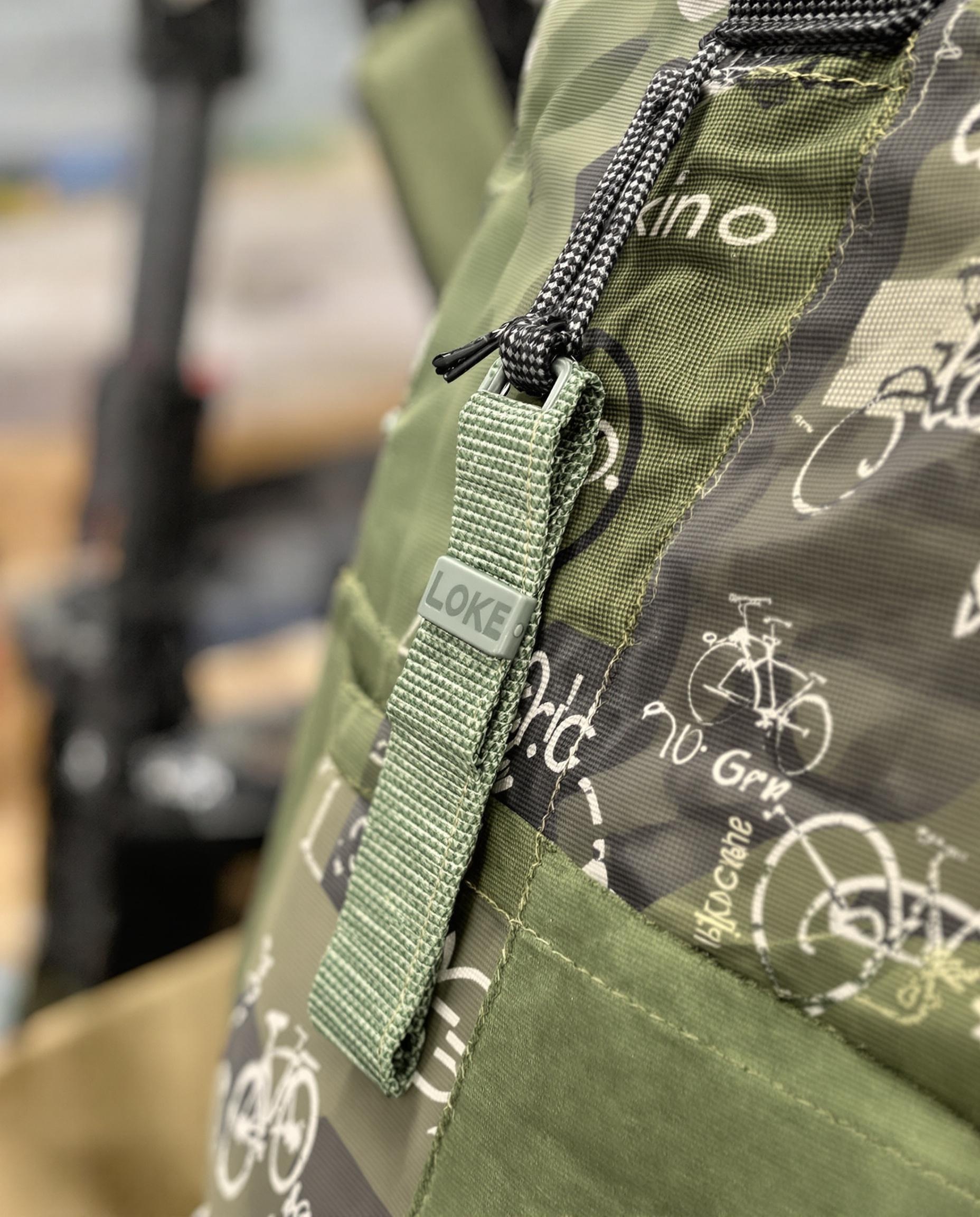 Patchwork vélo vert fixé sur une sacoche avec cordons et couture renforcée.