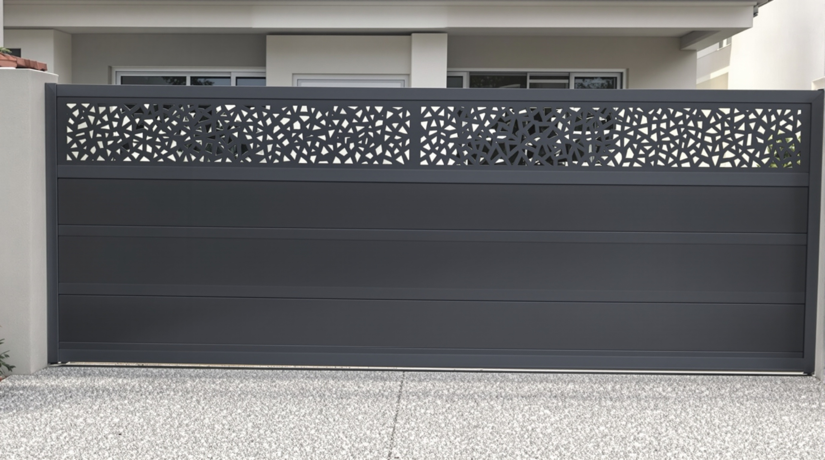 Un portail en aluminium coulissant sur mesure, avec un design moderne mélangeant des lames pleines en bas et une découpe laser décorative en haut, pour illustrer le potentiel du haut de gamme.