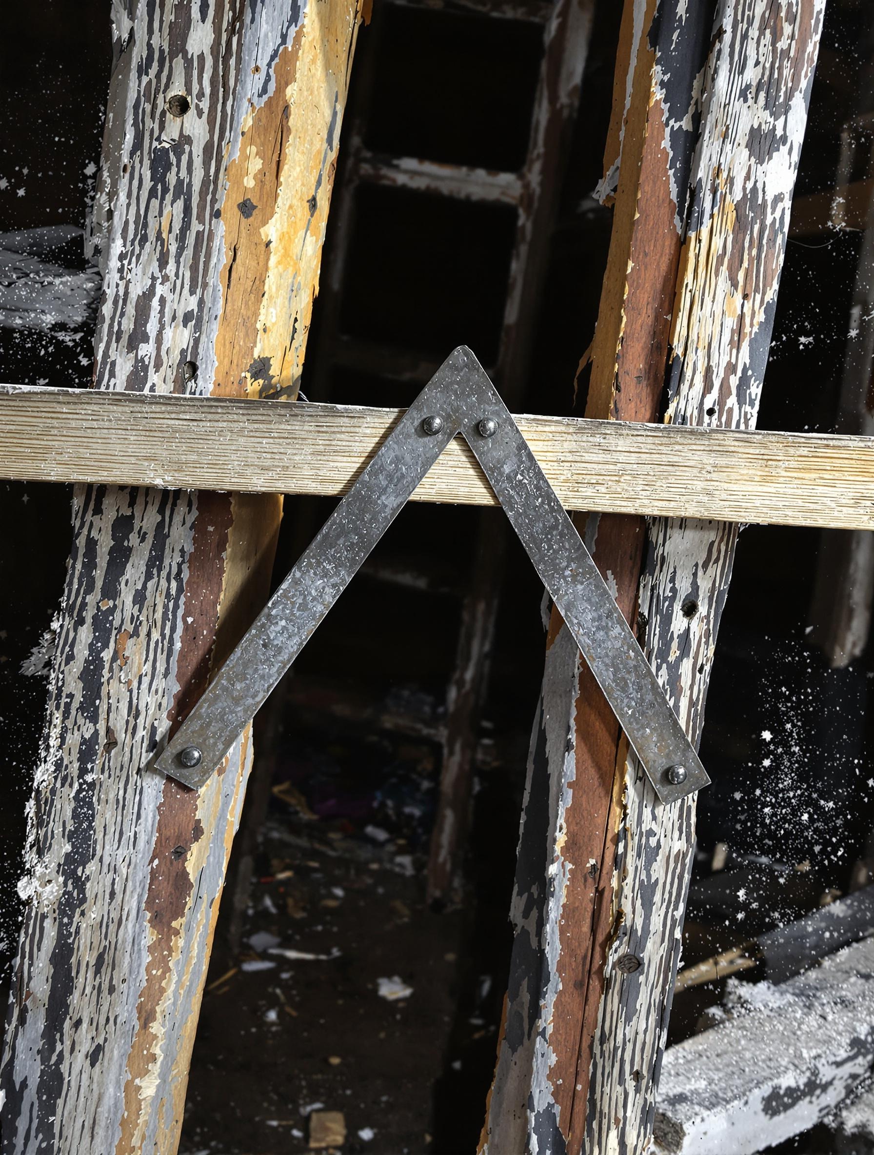 Taquet d'échelle métallique triangulé sur échelles en bois branlantes chantier